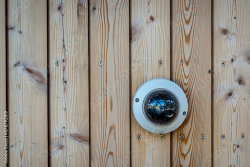 Security camera on the wooden wall of the building