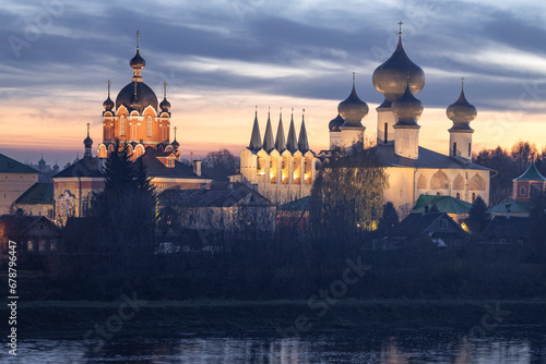 Church of the Exaltation of the Cross and the Assumption Cathedral of the Tikhvinsky Assumption Monastery of the Virgin Mary on a October twilight. Tikhvin. Leningrad region, Russia photo