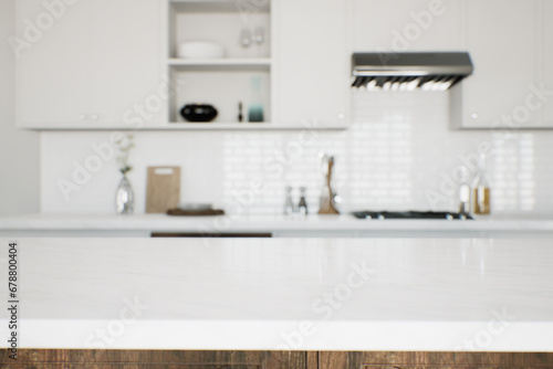 Focus on the marble countertop against the backdrop of kitchen appliances and utensils.