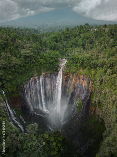 Discover Java's Natural Wonder: Aerial View of a Tropical Island, Lush Jungles, and the Enchanting Tumpak Sewu Waterfall by Semeru Volcano. Your Asian Vacation Destination