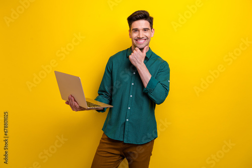 Photo of successful cheerful man wear stylish outfit hold wireless netbook working online isolated on yellow color background