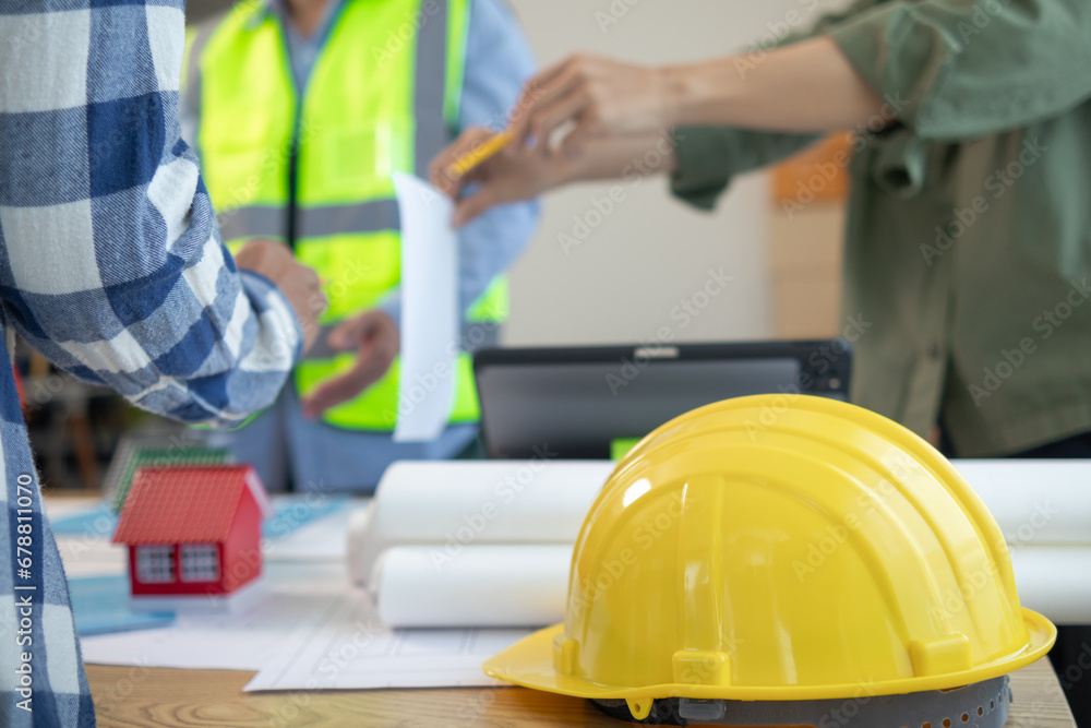 Yellow safety helmet were prepared for workers to wear before entering the construction area to prevent the danger of falling objects from working. Yellow safety helmet is placed on a wooden table. Yellow safety helmet were prepared for workers to wear before entering the construction area to prevent the danger of falling objects from working. Yellow safety helmet is placed on a wooden table.