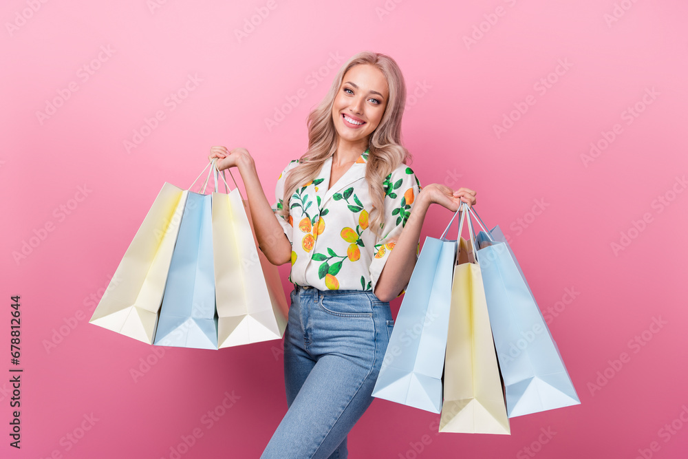 Portrait of gorgeous pretty woman with wavy hairstyle wear stylish print shirt holding shopping bags isolated on pink color background