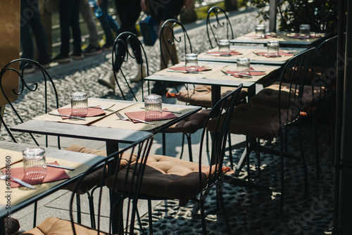 Tables served for lunch in a street cafe on a sunny day.