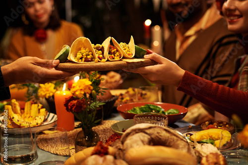 Close-up of people sitting at table and eating traditional food during celebration of holiday