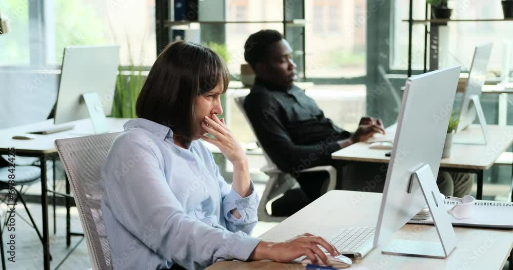 A bored businesswoman lets out a yawn at office desk, a sign of temporary fatigue from the routine. Despite the momentary boredom, commitment to work remains unwavering. A bored businesswoman lets out a yawn at office desk, a sign of temporary fatigue from the routine. Despite the momentary boredom, commitment to work remains unwavering.