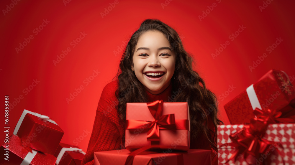A joyful woman with curly hair, laughing and holding a red gift with a ribbon, surrounded by more festively wrapped presents, all against a vibrant red background. A joyful woman with curly hair, laughing and holding a red gift with a ribbon, surrounded by more festively wrapped presents, all against a vibrant red background.
