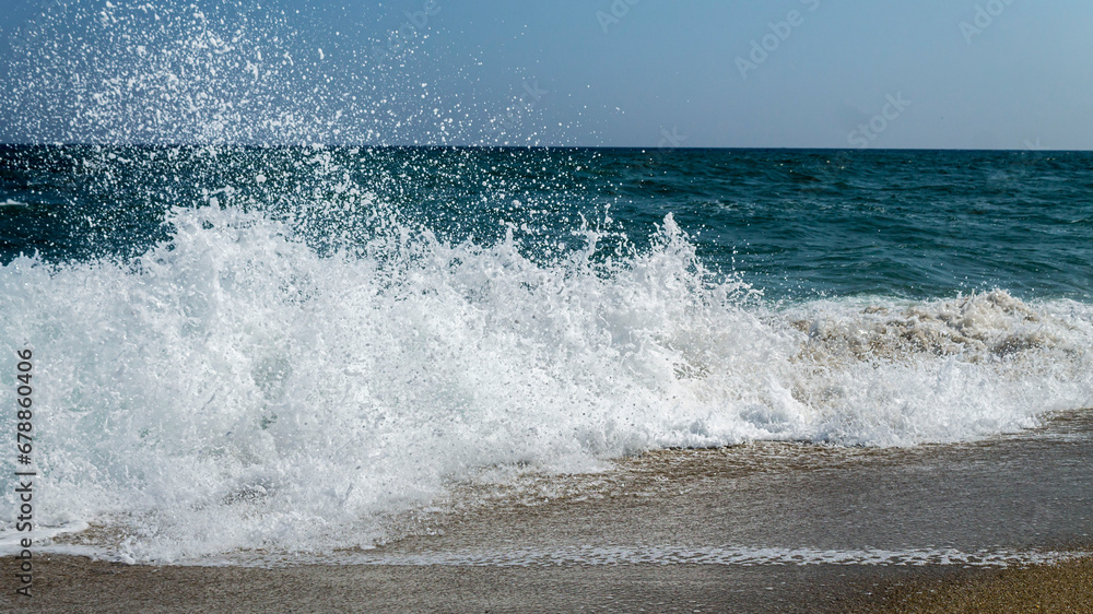 Splashing water drops of sea wave in a sunny day with blue sky. Splashing water drops of sea wave in a sunny day with blue sky.