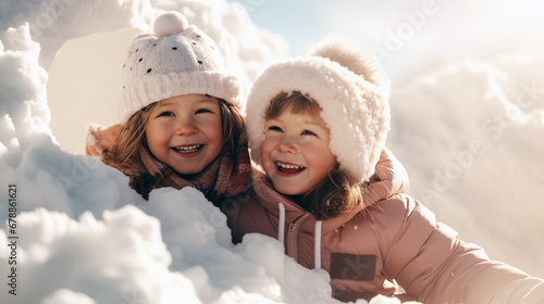 Two little children have fun playing in a snow fort on a sunny winter day. Winter retro clothes for cold weather.