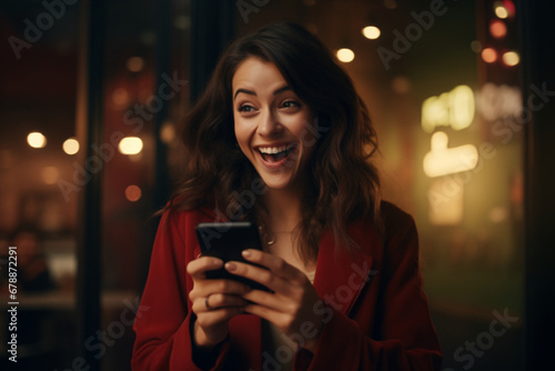 A woman looking up from her phone laughing, reading or seeing something funny on her phone