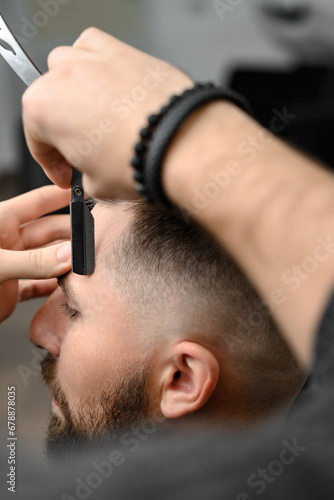 The barber makes the outline with a dangerous razor the undercut haircut