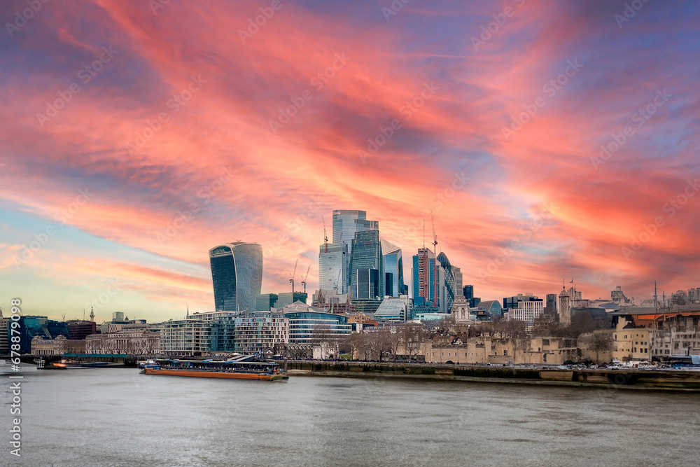 A view over the London skyline with the Thames river in the foreground and a beautiful sunset sky