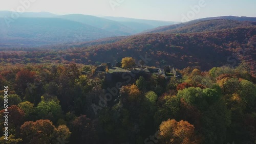 Aerial view of the ruins of Dregely Castle, with the forest in autumn colors in the background photo