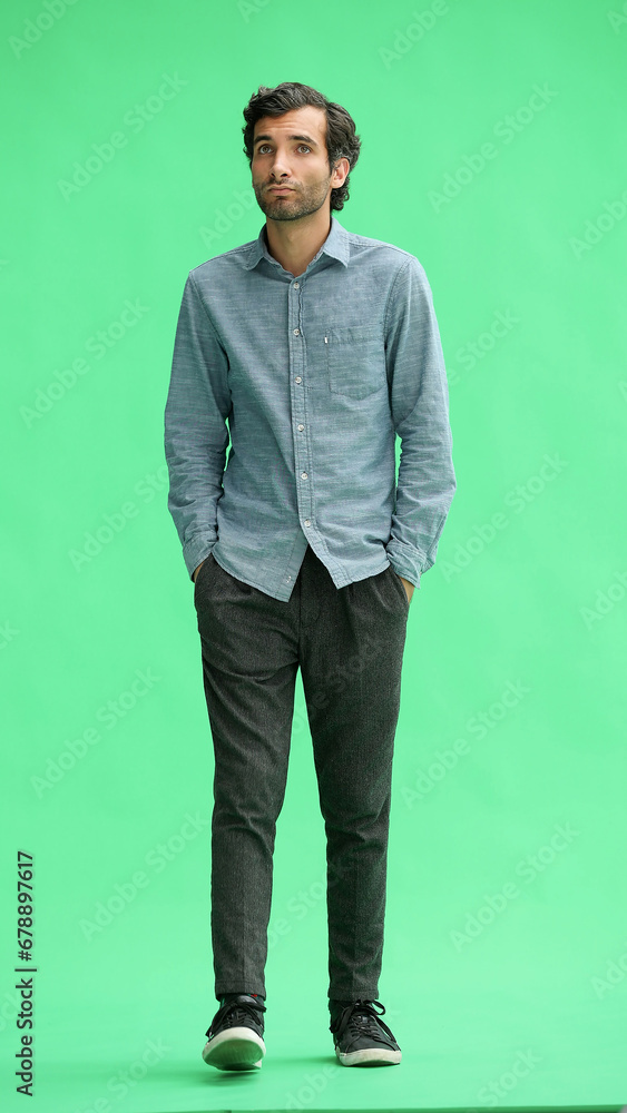 full-length portrait of a young man. standing isolated on green background