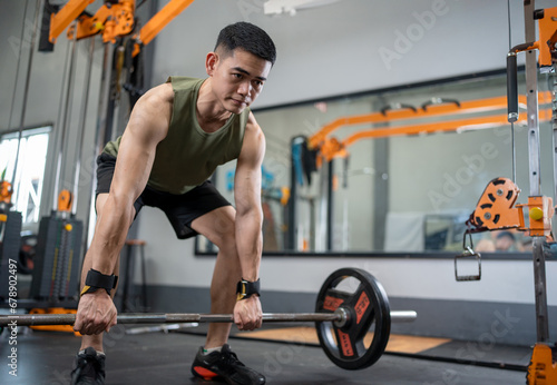 Young man lifting weights and exercising