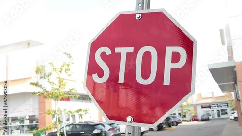 small mini miniature stop sign on metal post outside outdoors in mall plaza parking lot, close up photo