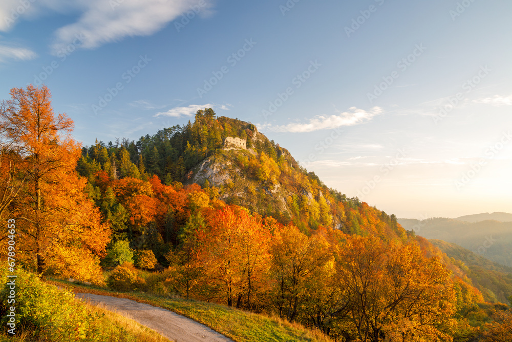 View of autumn landscape with The ruin of the medieval Vrsatec castle at sunset. The Vrsatec National Nature Reserve in the White Carpathian Mountains, Slovakia, Europe.