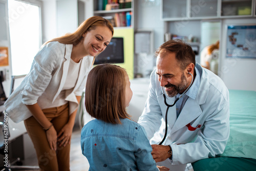 Pediatrician Interacting with Child and Mother During Consultation photo