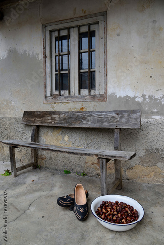 A pair of madreñas, typical clogs in Asturias, next to a basket full of apples, Gratila village, Nava municipality, Asturias, Spain photo