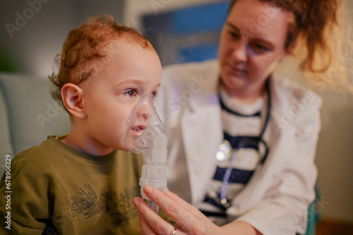 A sick little boy is inhaling medicine trough the nebulizer.