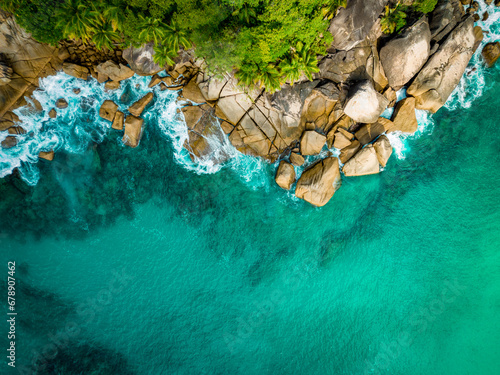 Aerial view Top down seashore. Waves crashing on rock cliff. Beautiful dark sea surface in sunny day summer background Amazing seascape top view seacoast at Anse Solei Beach, Mahe Seychelles