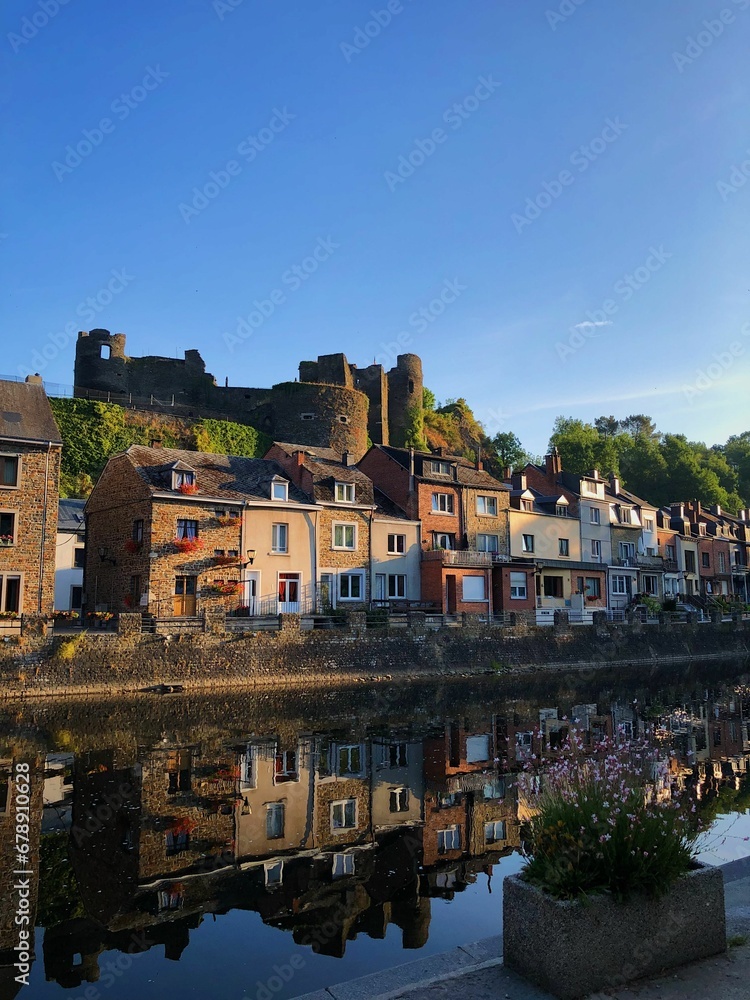 Ruined castle and a line of buildings with the reflection on the river