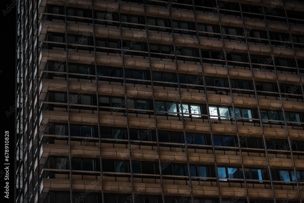 High-rise building with some windows with burning light
