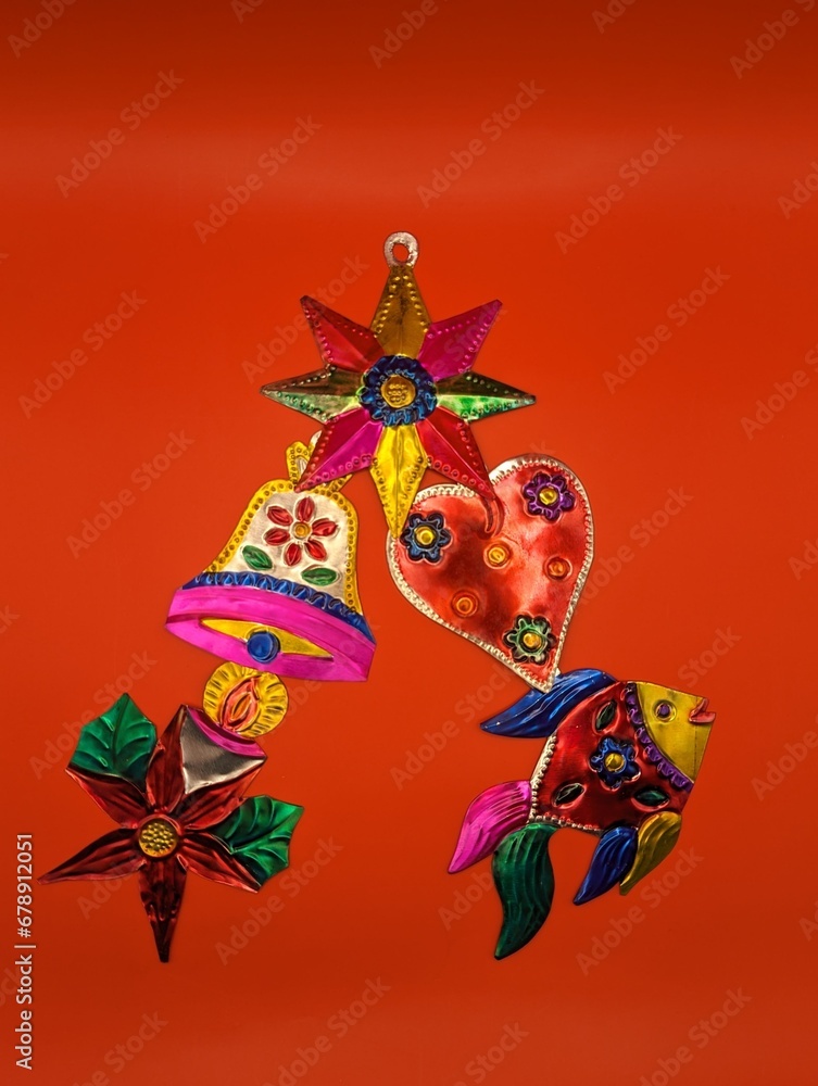 Mexican tin christmas decorations in christmas tree shape, red background