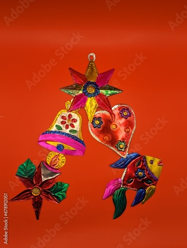 Mexican tin christmas decorations in christmas tree shape, red background