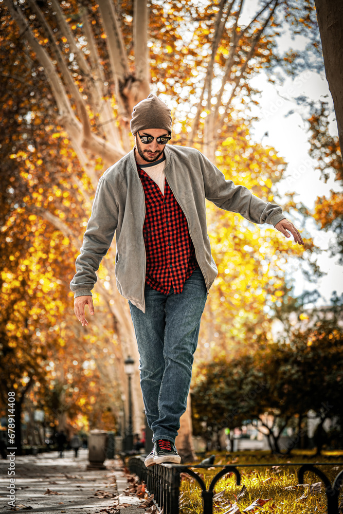 Stylish equilibrium: Red-checks, beanie-wearing guy balances on Madrid's autumn street.