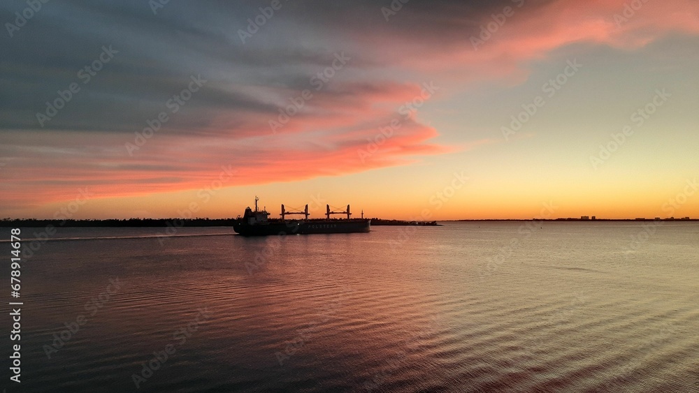 Beautiful shot of a silhouette of a ship on a sea at sunset