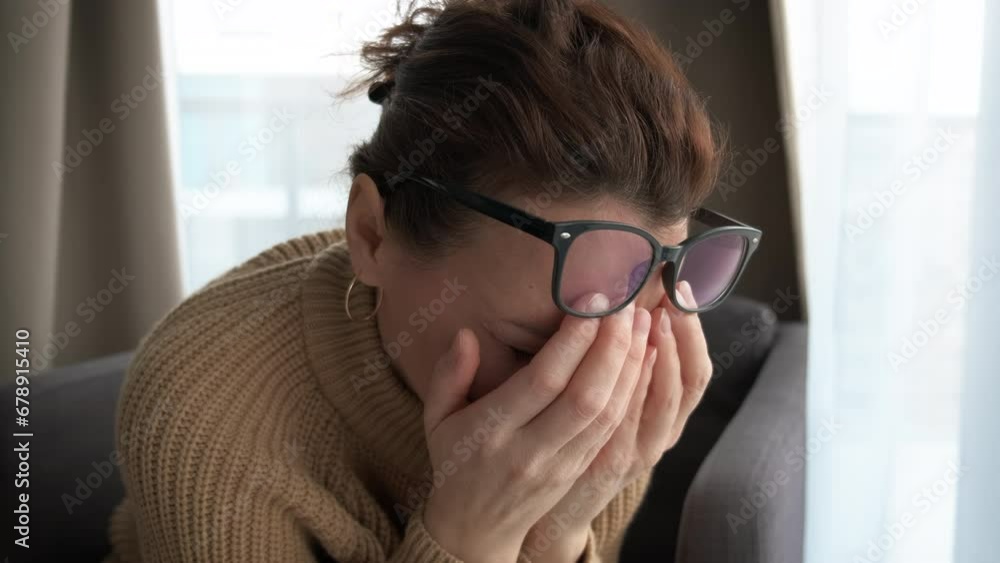 Lonely woman crying at the window. Women's problems in adulthood. Lonely woman crying at the window. Women's problems in adulthood.