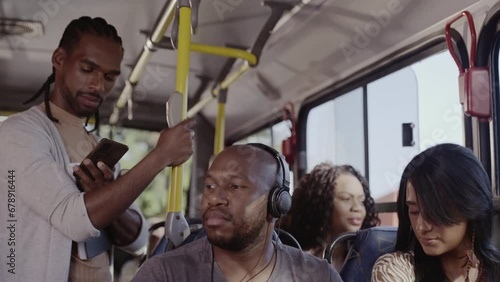 Man standing in crowded bus using his cell phone. Cinematic 4k.