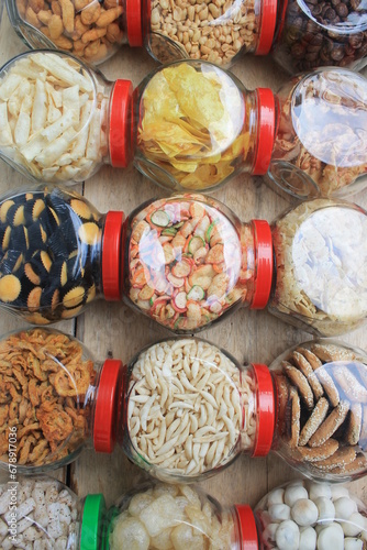 a row of various snacks in jars on the table photo