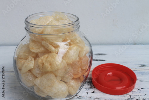 Indonesian snack called kerupuk cecek in a jar on the table photo
