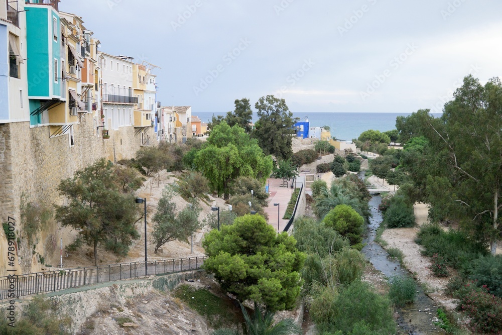Small river in Alicante between beautiful buildings and trees with the sea in the background, Spain