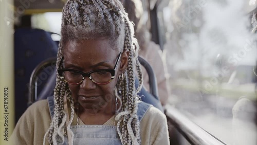 Mulher negra senior com penteado afro sentada no onibus. Cinematico 4k. photo