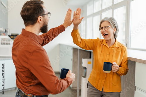 Fotografie Overjoyed business colleagues giving high five celebration success working together in modern office