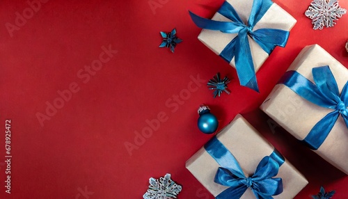 Wrapped Christmas craft gift boxes tied blue ribbons on dark red background