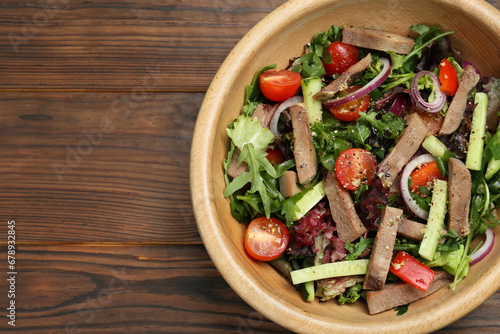 Delicious salad with beef tongue and vegetables on wooden table, top view. Space for text