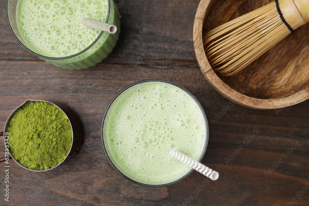 Tasty matcha smoothie, powder and bamboo whisk on wooden table, flat lay Tasty matcha smoothie, powder and bamboo whisk on wooden table, flat lay