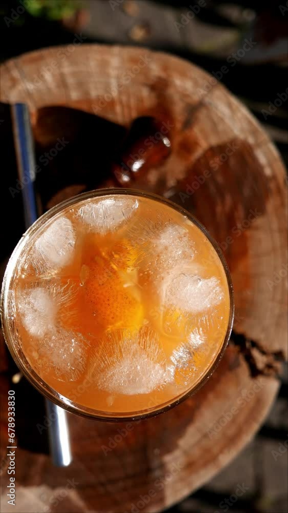 POV: a fresh tangerine Caipirinha on the table. Brazilian Caipirinha with cachaça (sugarcane liquor), tangerine slices, ice cubes and sugar. Caipirinha glass, high view. Bergamot Caipirinha, top angle POV: a fresh tangerine Caipirinha on the table. Brazilian Caipirinha with cachaça (sugarcane liquor), tangerine slices, ice cubes and sugar. Caipirinha glass, high view. Bergamot Caipirinha, top angle