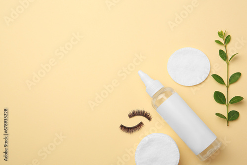 Flat lay composition with makeup remover and false eyelashes on yellow background. Space for text