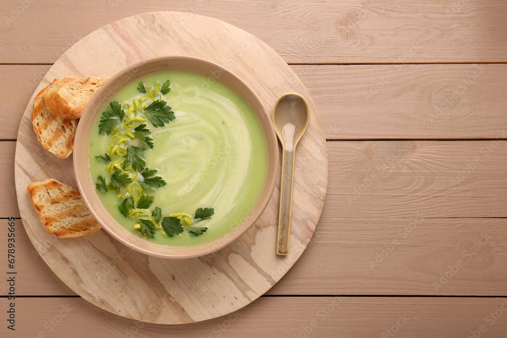 Delicious leek soup served on beige wooden table, top view. Space for text Delicious leek soup served on beige wooden table, top view. Space for text