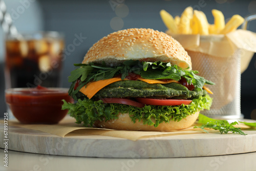 Tasty vegetarian burger served with french fries and soda drink on white table  closeup
