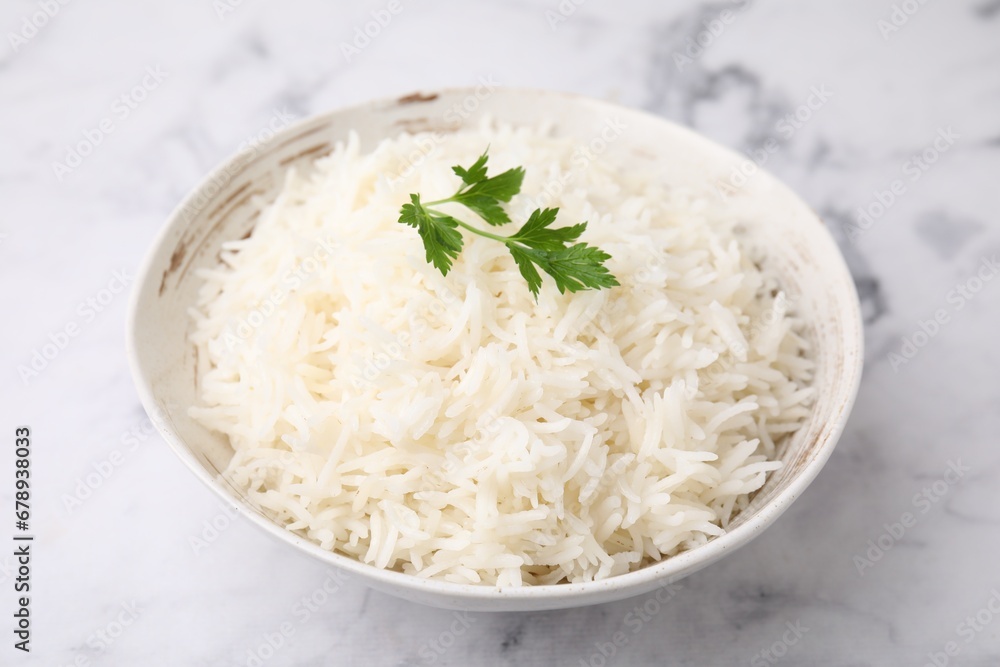 Bowl of delicious rice with parsley on light table, closeup Bowl of delicious rice with parsley on light table, closeup