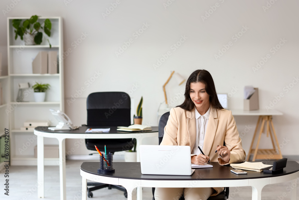 Beautiful businesswoman working at table in office Beautiful businesswoman working at table in office