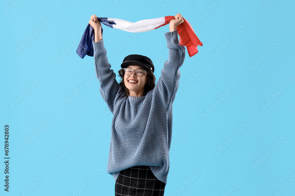 Young Asian woman with flag of France on blue background