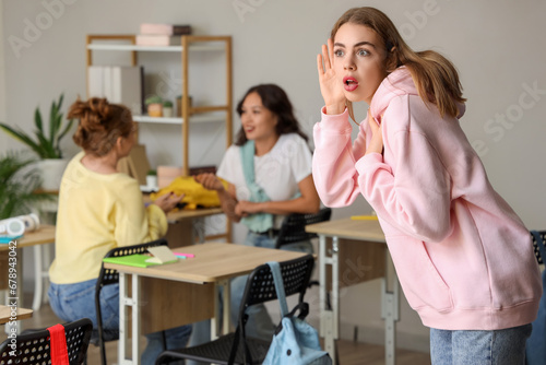 Female student trying to hear something in classroom