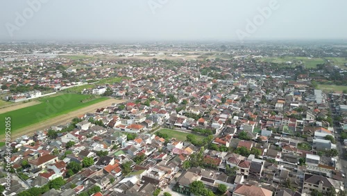 Aerial view of Solo City with buildings, crowded vehicles traffic in morning sunlight. Surakarta cityscape urban landscape. Population density is displacing agricultural land and forests.